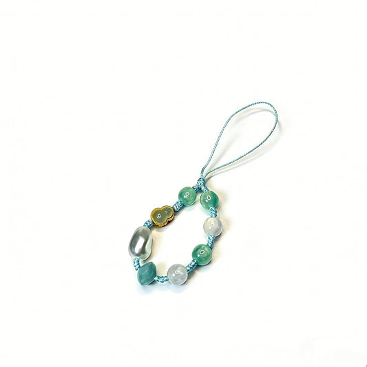 Handmade lucky phone charm with green jade beads, a cloud-shaped jade pendant, and silver pearls hand-knotted on a light blue cord by Case not Cake.