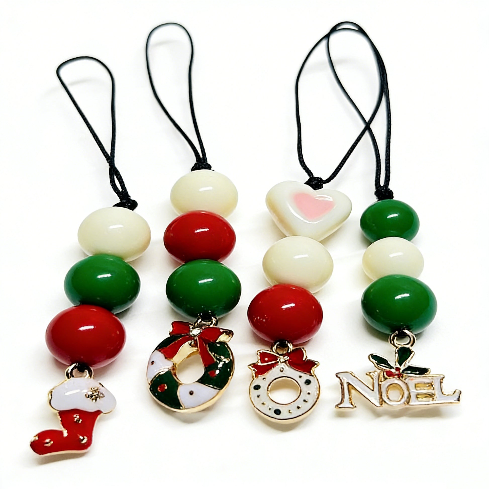 Handmade Christmas phone charms with red and green beads featuring stocking, wreath, and Noel enamel pendants by Case not Cake.