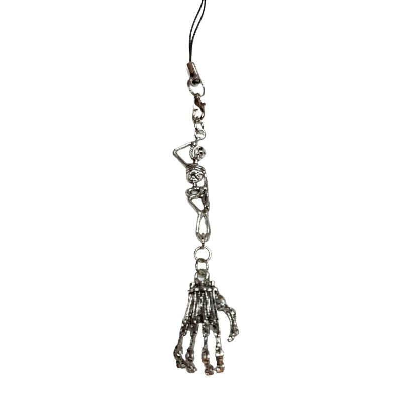 Handmade silver-tone skeletal hand phone charm attached to a white smartphone, featuring detailed bone structure and a gothic punk aesthetic.