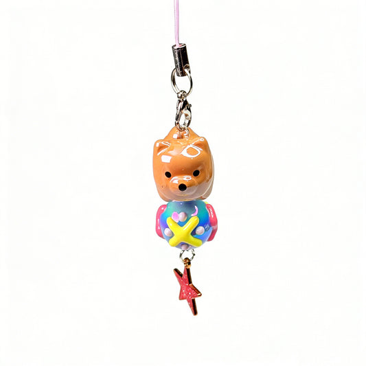 Handmade kawaii Shiba Inu phone charm with a colorful body and dangling glittery pink star on a pink cord by Case not Cake.